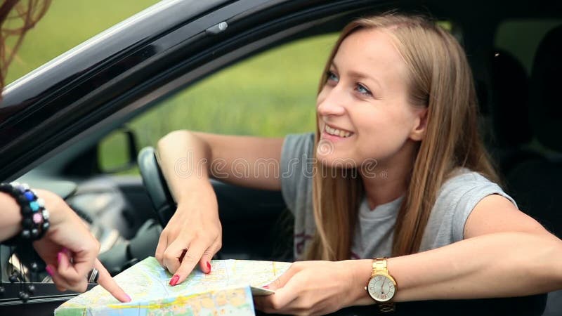 Jeune femme de touristes avec la voiture demandant la direction banque de vidéos