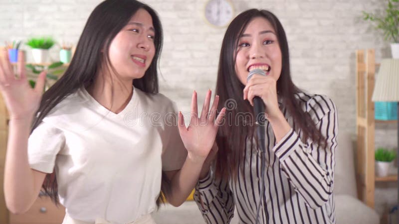 Jeune femme deux asiatique chanter au karaoké à la maison