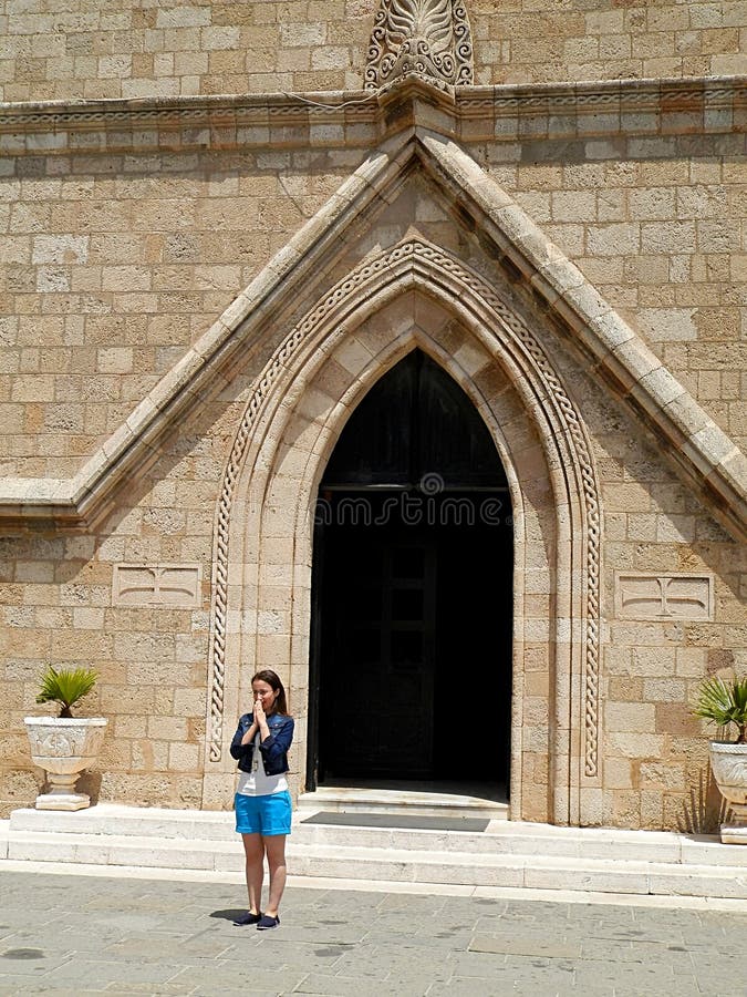 Jeune femme devant une porte d'église photographie stock libre de droits Jeune femme devant une porte d'église photographie stock libre de droits