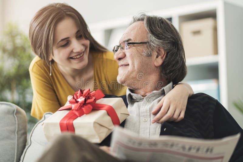 Jeune femme donnant à cadeau son père photos libres de droits Jeune femme donnant à cadeau son père photos libres de droits