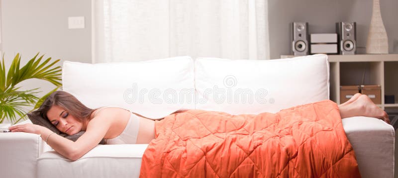 Jeune femme dormant sous un édredon image stock Jeune femme dormant sous un édredon image stock