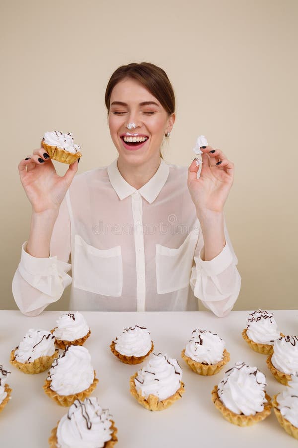 Jeune femme drôle gaie mangeant des gâteaux et rire photo stock