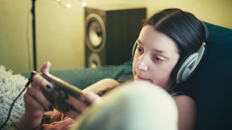 Jeune femme détendue profitant du temps de l'écran dans une ambiance cosy banque de vidéos