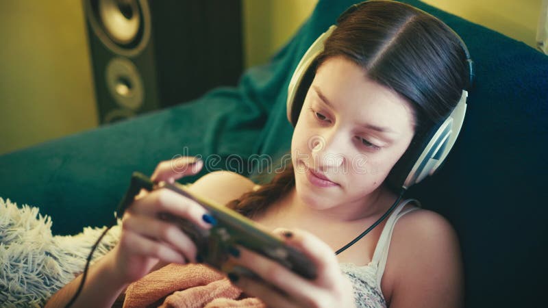 Jeune femme détendue profitant du temps de l'écran dans une ambiance cosy banque de vidéos
