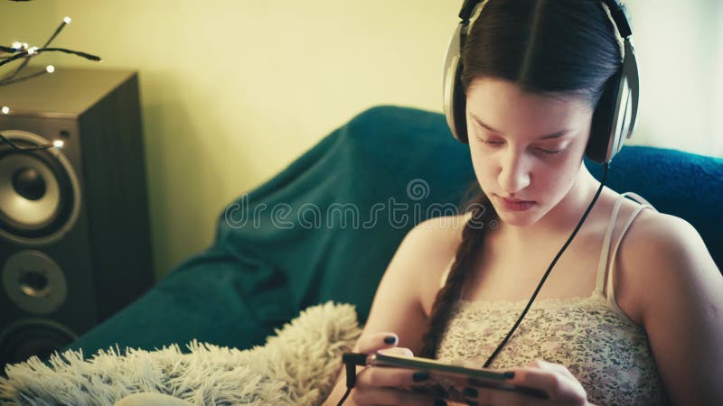Jeune femme détendue profitant du temps de l'écran dans une ambiance cosy banque de vidéos
