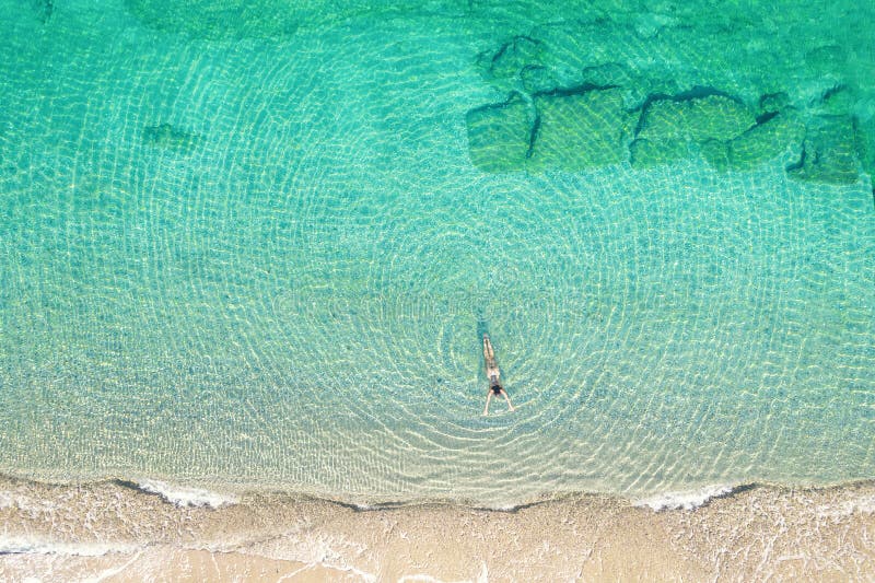 Jeune femme en bikini nageant dans l'eau de mer sur la plage. vue depuis le haut. vue de drone supérieure. photographie stock libre de droits