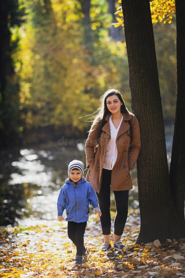 Jeune femme en parc en automne avec un enfant Mère avec le fils images libres de droits Jeune femme en parc en automne avec un enfant Mère avec le fils images libres de droits