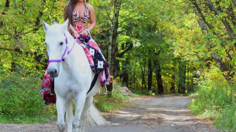 Jeune femme en robe gipsy à cheval blanc par clips vidéos