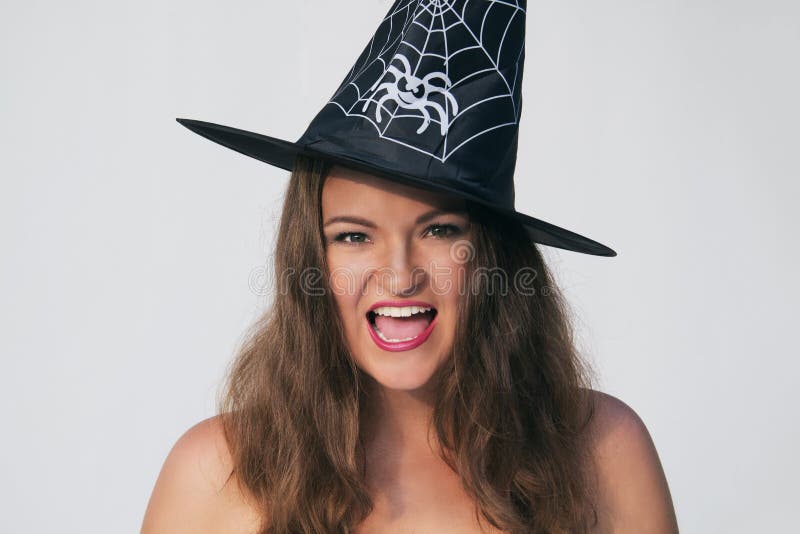 Excited young woman in Halloween witch hat on a white background. Excited young woman in Halloween witch hat on a white background