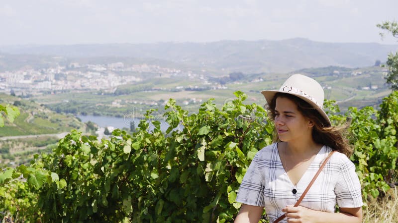 Jeune femme entre le champ des ceps de vigne avec des raisins