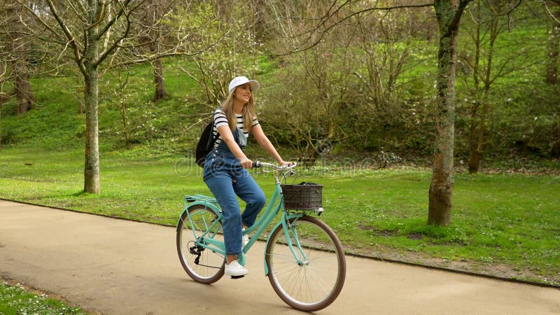 Jeune femme faisant du vélo dans un parc banque de vidéos