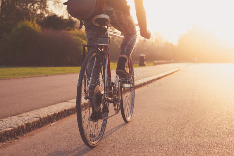 Jeune femme faisant un cycle en parc au coucher du soleil photos libres de droits Jeune femme faisant un cycle en parc au coucher du soleil photos libres de droits
