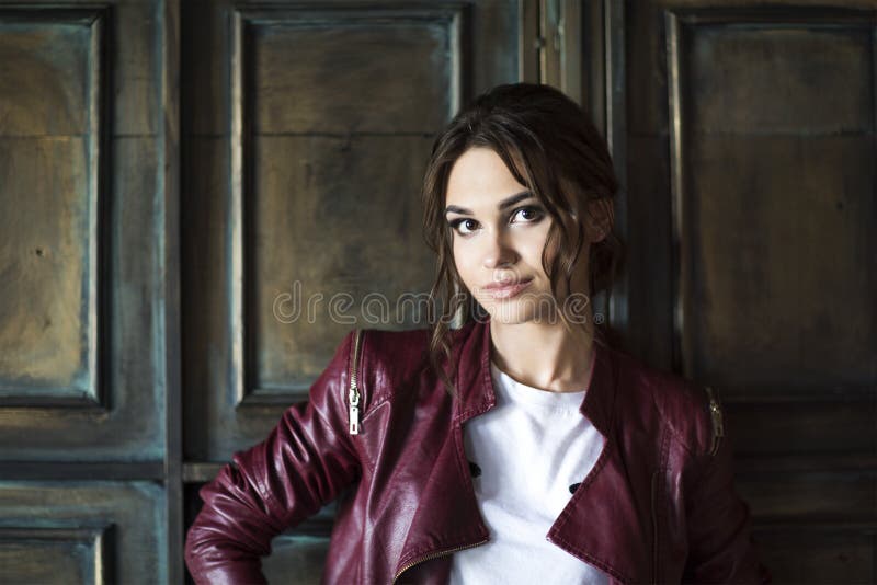 Jeune femme fascinante dans la veste en cuir rouge photographie stock Jeune femme fascinante dans la veste en cuir rouge photographie stock