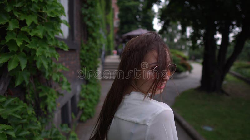 Jeune femme gaie en marchant dans la rue calme