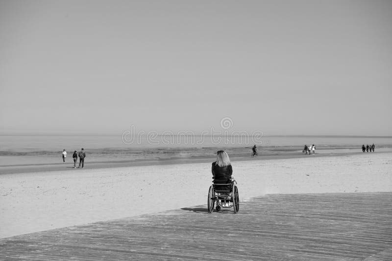 Jeune femme handicapée seule sur la plage Jour d'?t? ensoleill? image stock Jeune femme handicapée seule sur la plage Jour d'?t? ensoleill? image stock