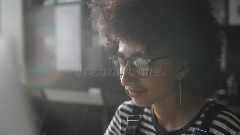 Jeune femme haute étroite dans l'oeil de verre de mode à naviguer sur Internet de moniteur. Fonctionnement femelle élégant avec l' clips vidéos