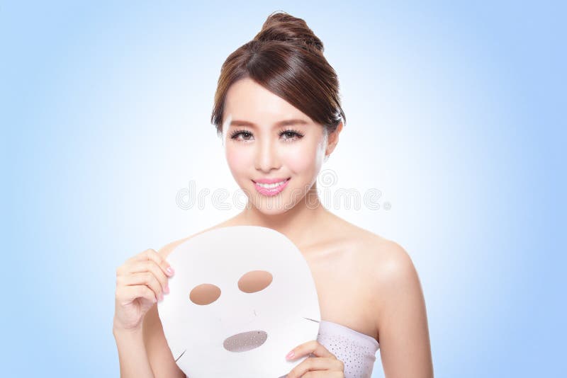 Happy Young woman with cloth facial mask isolated on blue background, concept for skin care, asian. Happy Young woman with cloth facial mask isolated on blue background, concept for skin care, asian