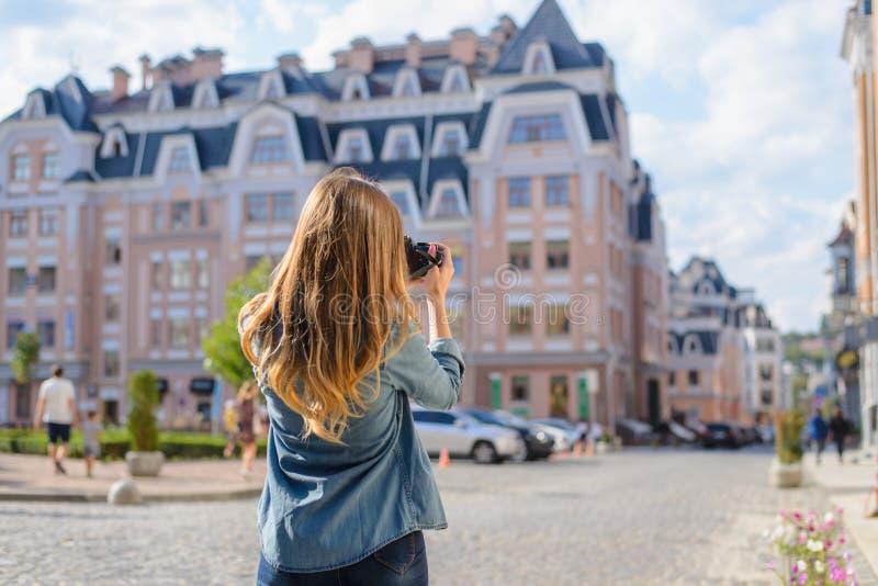 Jeune femme heureuse, enthousiaste, élégante rapportant la photo du point de repère au bel arrière euripean nouveau vieux de vill photographie stock libre de droits Jeune femme heureuse, enthousiaste, élégante rapportant la photo du point de repère au bel arrière euripean nouveau vieux de vill photographie stock libre de droits