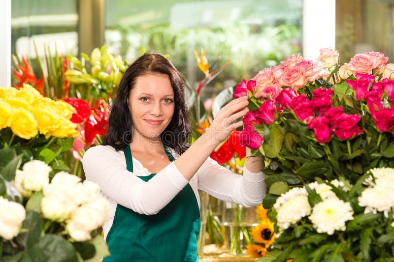 Jeune femme heureuse s'chargeant du fleuriste de fleurs images stock Jeune femme heureuse s'chargeant du fleuriste de fleurs images stock