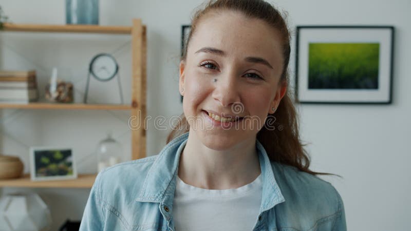 Jeune femme heureuse souriant et riant regardant la caméra debout dans la salle lumineuse moderne clips vidéos