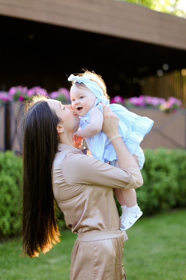 Jeune femme heureuse tenant et embrassant peu de fille photo libre de droits Jeune femme heureuse tenant et embrassant peu de fille photo libre de droits