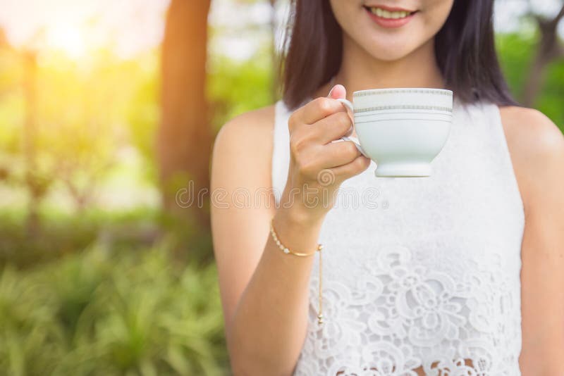 Jeune femme heureuse tenant la tasse ou le thé de café dans le matin image libre de droits Jeune femme heureuse tenant la tasse ou le thé de café dans le matin image libre de droits