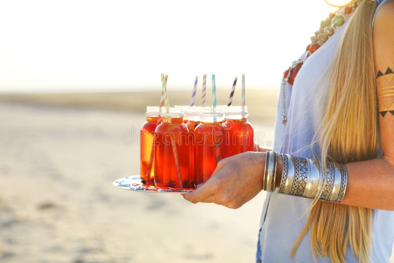 Jeune femme heureuse tenant un plat avec boissons à la partie d'été image libre de droits Jeune femme heureuse tenant un plat avec boissons à la partie d'été image libre de droits