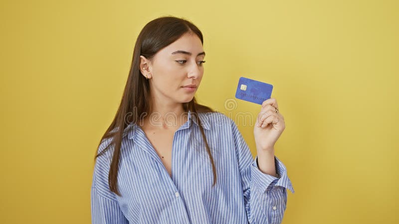 Jeune femme hispanique confiante délibération des mouvements financiers carte de crédit en main. belle expression libre isolée sur banque de vidéos