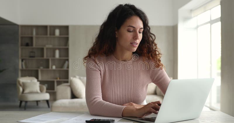 Jeune femme hispanique heureuse faisant la paperasse financière domestique. banque de vidéos