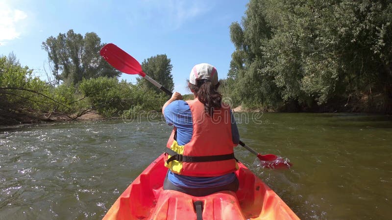 Jeune femme hispanique kayak sur le fleuve ter une journée ensoleillée Catalogne d'été de l'Espagne