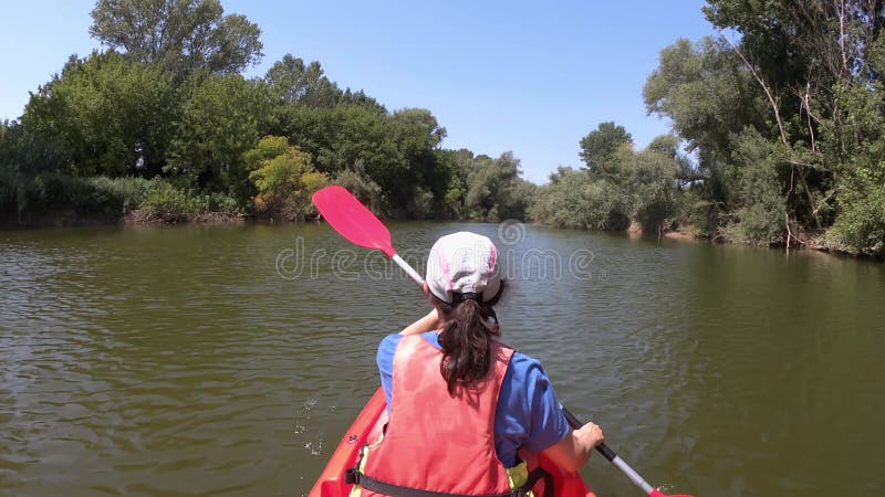 Jeune femme hispanique kayak sur le fleuve ter une journée ensoleillée d'été. La Catalogne en Espagne