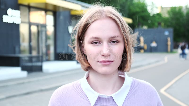 Jeune femme joyeuse aux cheveux courts agitée par un vent léger banque de vidéos