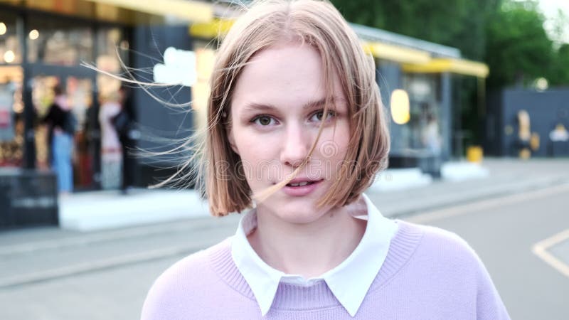 Jeune femme joyeuse aux cheveux courts agitée par un vent léger banque de vidéos