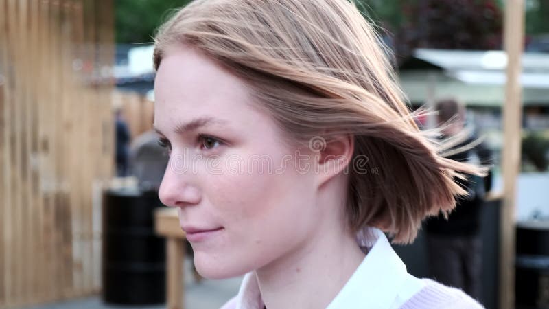 Jeune femme joyeuse aux cheveux courts agitée par un vent léger banque de vidéos