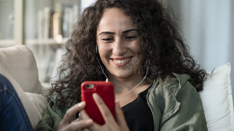 Jeune femme ? l'aide du t?l?phone portable ? la maison photo libre de droits Jeune femme ? l'aide du t?l?phone portable ? la maison photo libre de droits