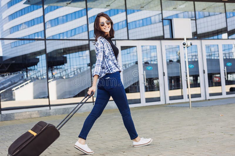 Jeune femme marchant avec la valise de bagage, les vacances, le voyage et le concept actif de mode de vie photographie stock Jeune femme marchant avec la valise de bagage, les vacances, le voyage et le concept actif de mode de vie photographie stock
