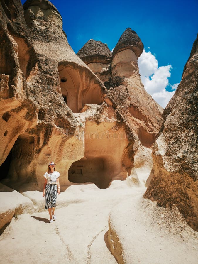 Jeune femme marchant parmi la vallée de Pasabag dans Cappadocia photo stock Jeune femme marchant parmi la vallée de Pasabag dans Cappadocia photo stock