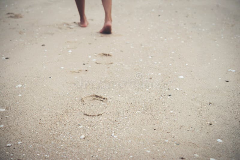 Jeune femme marchant sur la plage avec nu-pieds photographie stock libre de droits Jeune femme marchant sur la plage avec nu-pieds photographie stock libre de droits