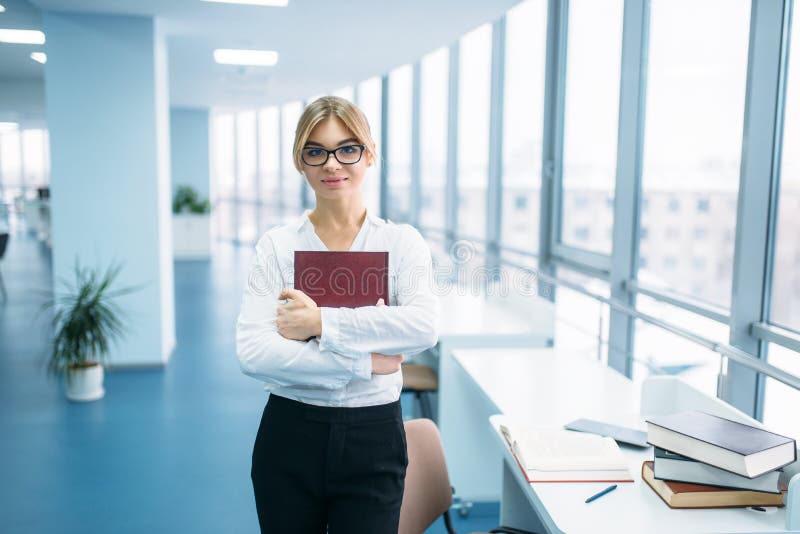 Jeune femme mignonne avec le livre dans la bibliothèque photo libre de droits Jeune femme mignonne avec le livre dans la bibliothèque photo libre de droits