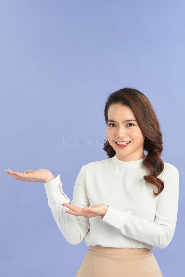 Jeune femme montrer quelque chose et porter casual avec fond de couleur isolé asiatique photo libre de droits