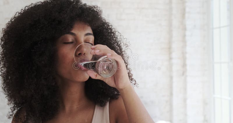 Jeune femme multiraciale boire de l'eau tous les matins habitude routine après l'exercice du matin clips vidéos