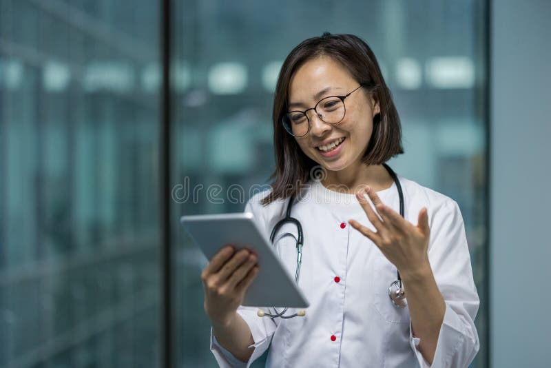 Jeune femme médecin avec succès utilisant un ordinateur tablette appel vidéo. Femme en habit médical blanc consultant des patients images libres de droits