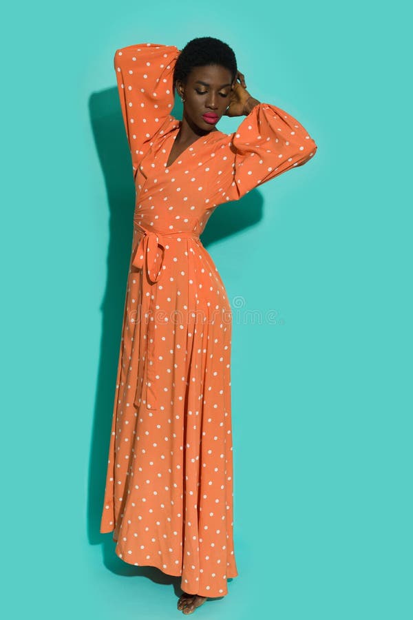 Jeune femme noire en robe orange polka dot maxi photo libre de droits