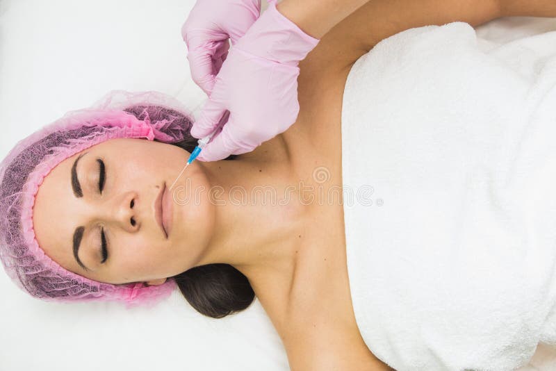Jeune femme obtenant l'injection cosmétique dans la clinique de beauté photos stock Jeune femme obtenant l'injection cosmétique dans la clinique de beauté photos stock