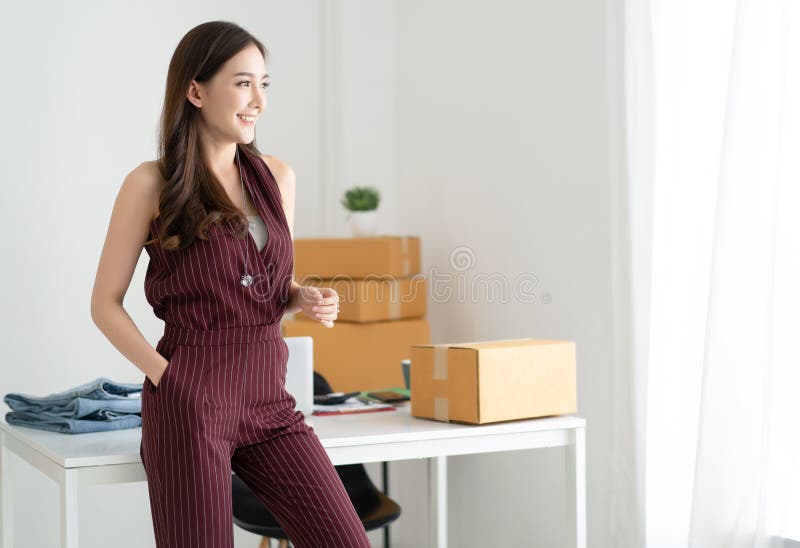 Jeune femme occasionnelle asiatique travaillant la petite position d'entrepreneur recherchant et souriant ? la maison bureau Cr?e photos stock Jeune femme occasionnelle asiatique travaillant la petite position d'entrepreneur recherchant et souriant ? la maison bureau Cr?e photos stock