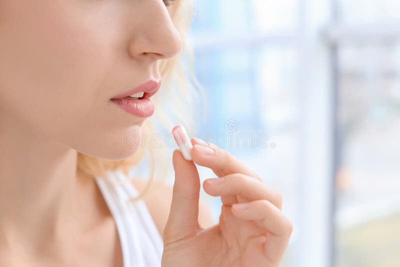Jeune femme prenant la pillule image stock Jeune femme prenant la pillule image stock