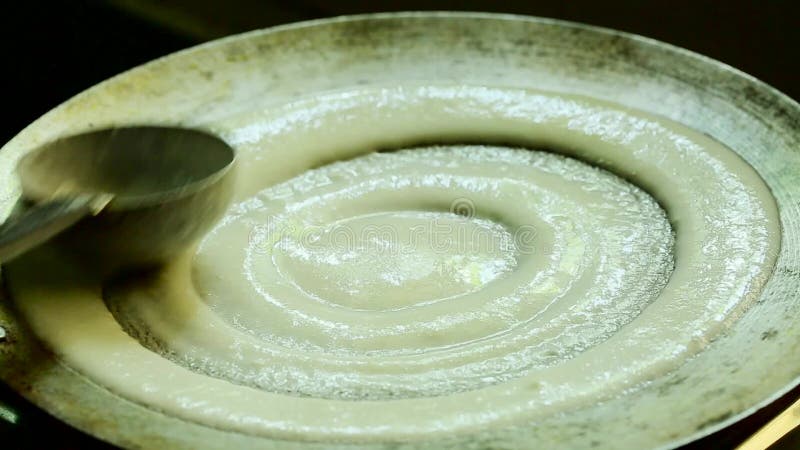 Jeune femme préparant le petit déjeuner indien du sud traditionnel Dosa populaire dans l'Indien du sud banque de vidéos