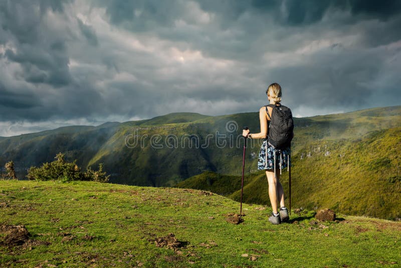 Jeune femme randonnée dans les montagnes. profiter d'une belle vue sur le paysage verdoyant avec ciel spectaculaire image libre de droits