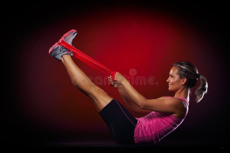 Jeune femme s'exerçant avec la bande élastique de forme physique images libres de droits Jeune femme s'exerçant avec la bande élastique de forme physique images libres de droits