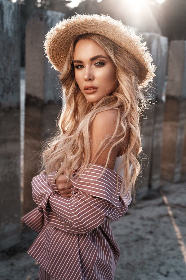 Jeune femme sensuelle, attirante et magnifique avec de longs cheveux blonds lâches dans un chapeau de paille Paysage de campagne, photographie stock libre de droits Jeune femme sensuelle, attirante et magnifique avec de longs cheveux blonds lâches dans un chapeau de paille Paysage de campagne, photographie stock libre de droits